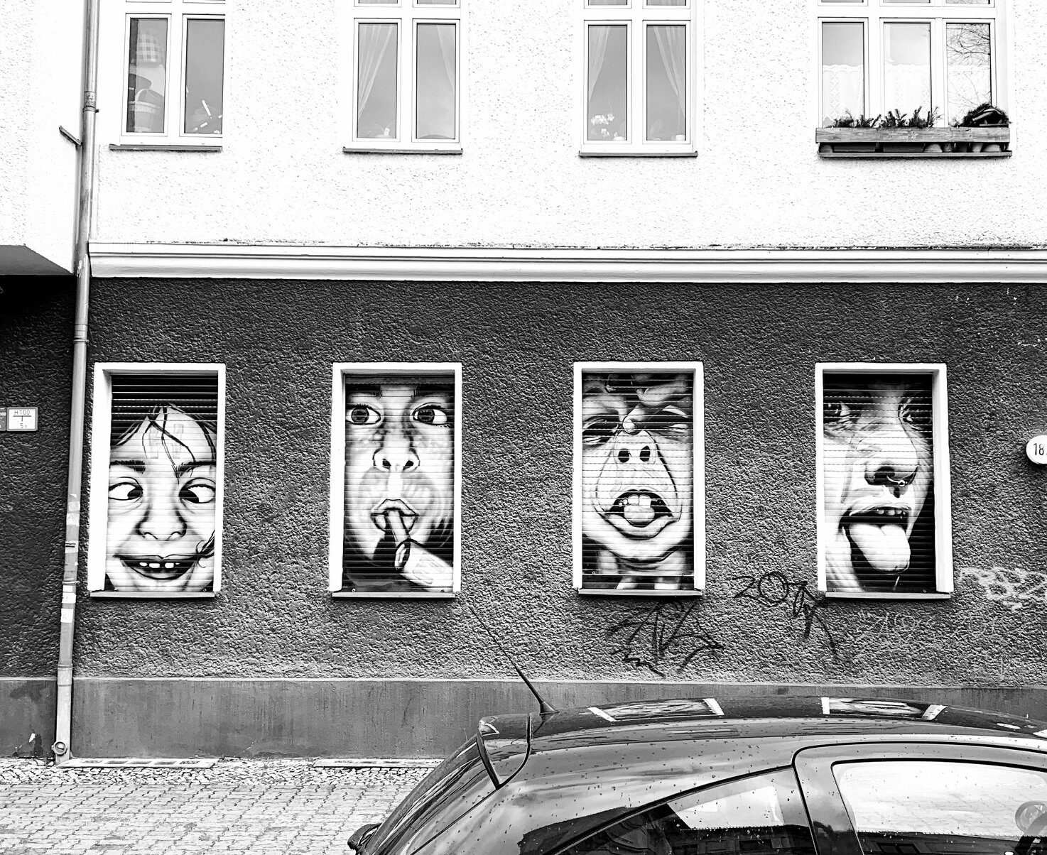 Gesprühte Kindergesichter auf Rolladen einer Kinderarztpraxis in Berlin Pankow