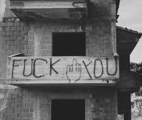 Abbruchhaus mit Fuck you auf dem Balkon